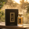 Kayaan Gold on amber wood with vetiver mist in sunlight; unisex outdoor Malaysian retreat; bottle and box clearly visible.
