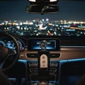 Qahir Man by Al Wataniah on car dashboard with city lights at night