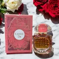 Perfume bottle and packaging of 'Candy Rose' with red roses on a marble surface