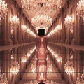 Glitz & Glam on mirrored ballroom floor with endless chandelier reflections; bottle and box clearly visible.