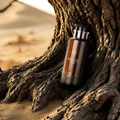 Voyage perfume bottle nestled in a tree trunk on a sandy beach