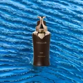 Stellar Oud perfume bottle on a blue water background