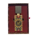 Decorative perfume bottle with intricate design in a maroon box