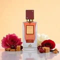 Perfume bottle labeled 'Scarlet' with flowers and candies on a reflective surface