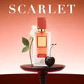 Perfume bottle labeled 'Scarlet' on a table with a blurred background