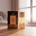 Atheeri bottle and box in Malaysian sunrise with rose‑gold glow and soft vanilla aura; cinematic realism, clear product