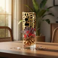 bottle Jasoor Lattafa Decorative glass vase with gold geometric design and flowers on a wooden table.