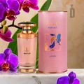 MAYAR Lattafa perfume bottle and pink cylindrical container with purple orchids on a marble surface