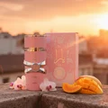 Woman perfume bottle on balcony at golden hour with tangerine sky and orchid petals – Yara vanilla tropical note