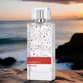 Perfume bottle labeled 'Aromatic Rouge' on a rocky surface with a sunset over water background
