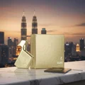 Gold perfume bottle and packaging with city skyline in the background