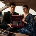 Man and woman holding a luxury product box in a car