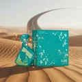 Teal bottle and box with floral design on sand dunes