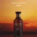 Bottle of Lueur d'Espoir Ambre perfume with a sunset background