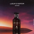 Bottle of Lueur d'Espoir arena perfume against a colorful sky background