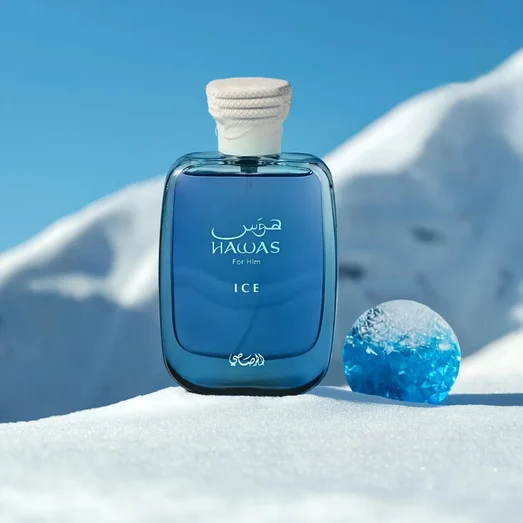Blue perfume bottle labeled 'Hawas Ice for Him Rasasi for men' on a snowy background