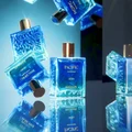 Blue rayhaan Pacific perfume bottles with metallic caps on a reflective surface.