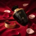Carino Black by Rue Broca perfume bottle on velvet cloth with gold bracelet luxury women scent
