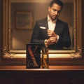 Malay man with Rue Broca Exotic Heritage perfume bottle on dresser mirror preparation men fragrance