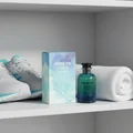 Perfume bottle and packaging labeled 'Above the Clouds' on a shelf with white sneakers and a towel