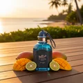 Unisex perfume bottle on teak deck at tropical coastline golden hour with mango and bergamot – Al Barari Coral
