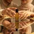 Malay couple sharing unisex perfume reflection gold mirror