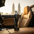 Itqan Noir by Zimaya perfume bottle on convertible car seat near Petronas Towers golden hour