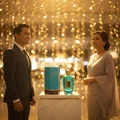 Rabab Blue 100ml - Malaysian couple at arrivals with Luxe Journey bottle and box on marble plinth; warm light confetti; balanced unisex frame