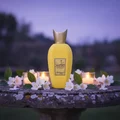 Rabab Pulp by Zimaya perfume bottle on garden stone table with jasmine candles golden dusk
