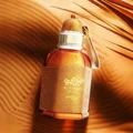 Perfume bottle with gold cap on a sand dune background