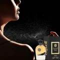 Perfume bottle and packaging with a person spraying perfume against a black background